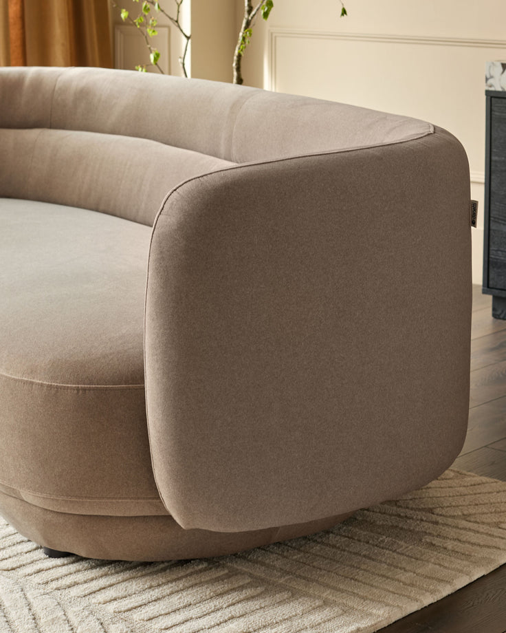 Henry 3-seater sofa in mocha fabric, shown from side angle displaying curved armrest and rounded form on neutral rug.