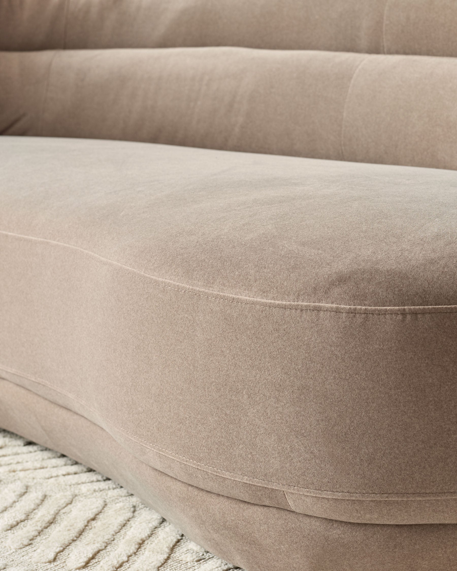 Henry 3-seater sofa in mocha fabric, curved design with stitched seams detail, close-up of seat cushion and armrest.