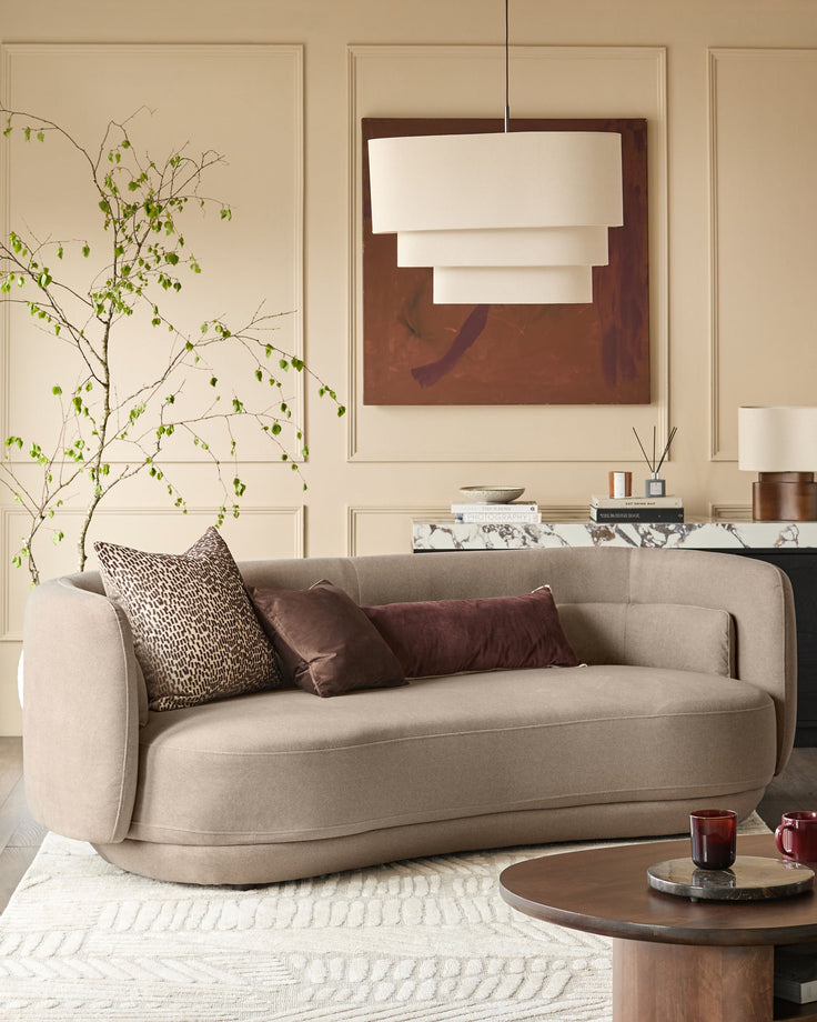 Henry 3-seater sofa in mocha fabric with curved arms and rounded base, styled in a modern living room setting.