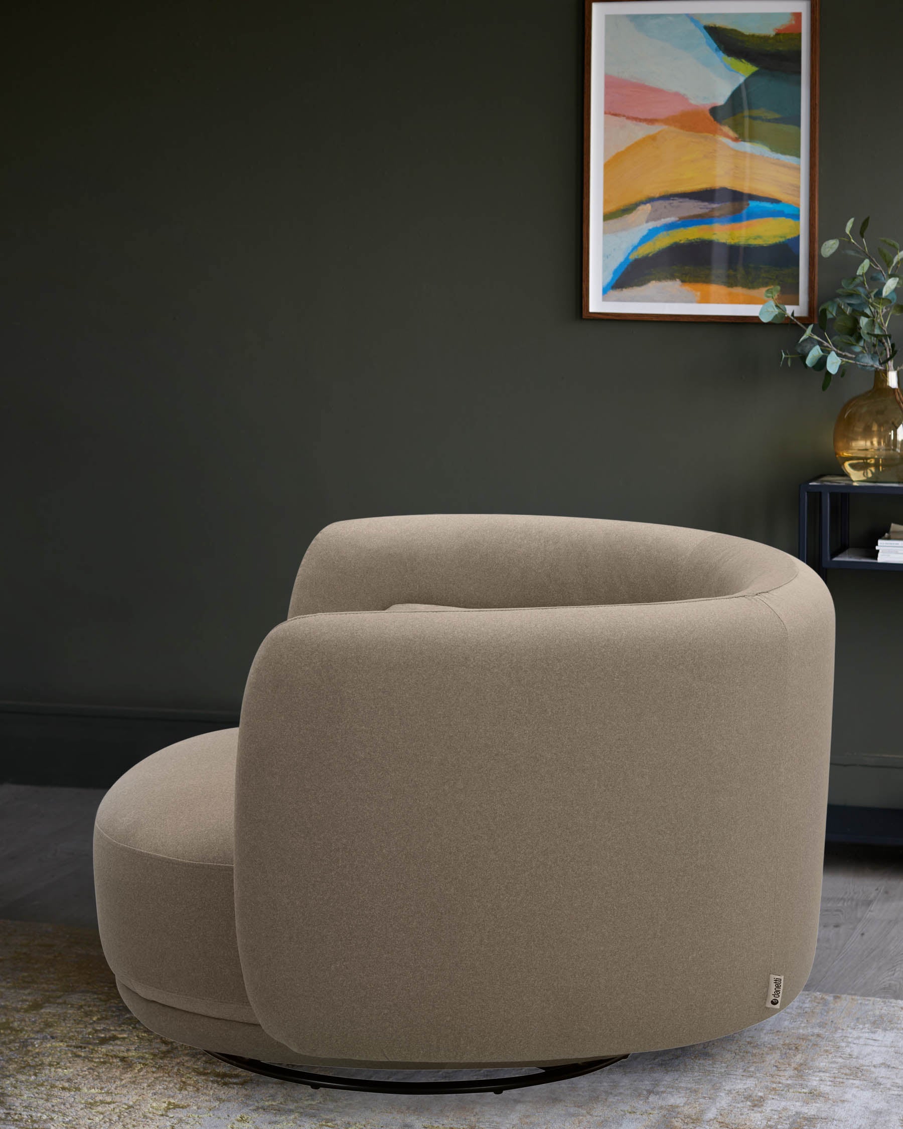 A cosy, swivel armchair in neutral tones, set against a dark green wall with a framed artwork.