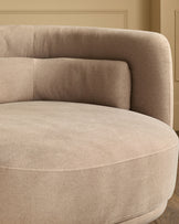 Henry swivel love seat in mocha fabric, curved rounded design with quilted back cushions, shown from side angle.
