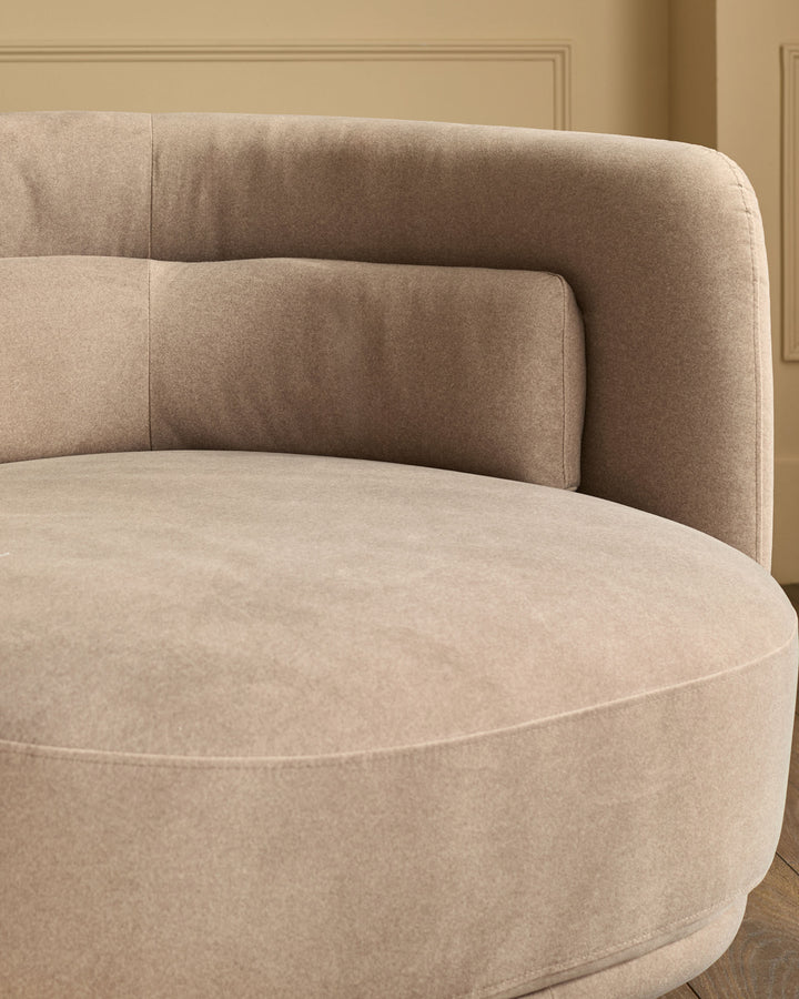 Henry swivel love seat in mocha fabric, curved rounded design with quilted back cushions, shown from side angle.