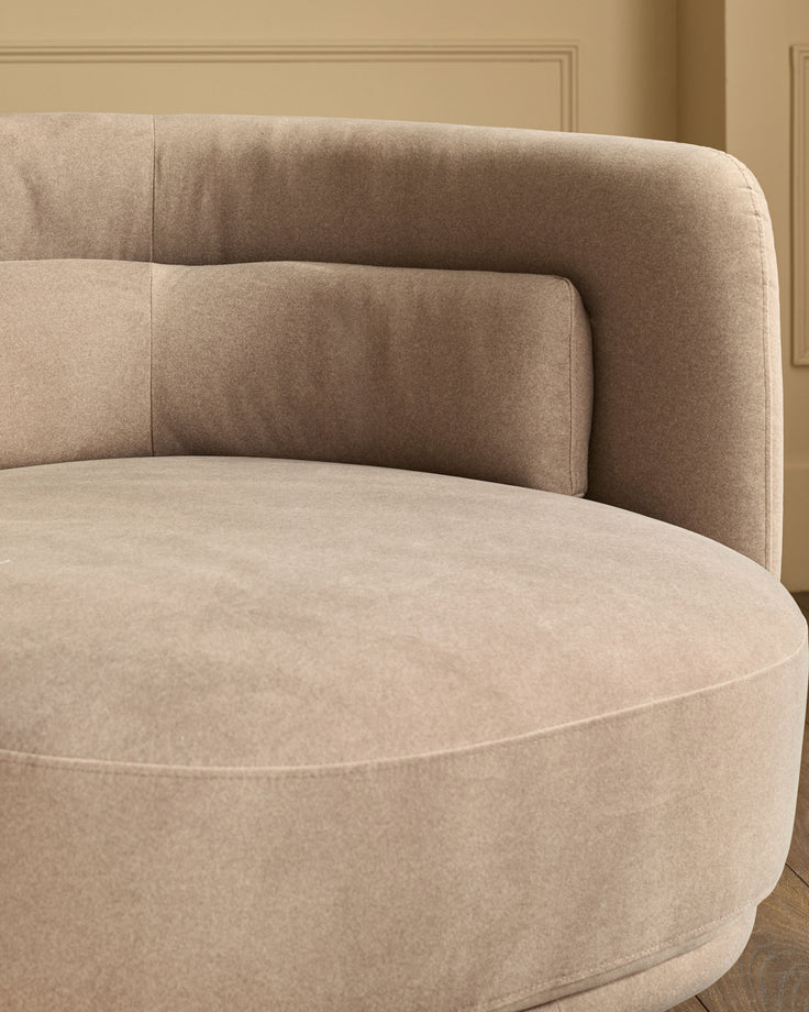 Henry swivel love seat in mocha fabric, curved rounded design with quilted back cushions, shown from side angle.