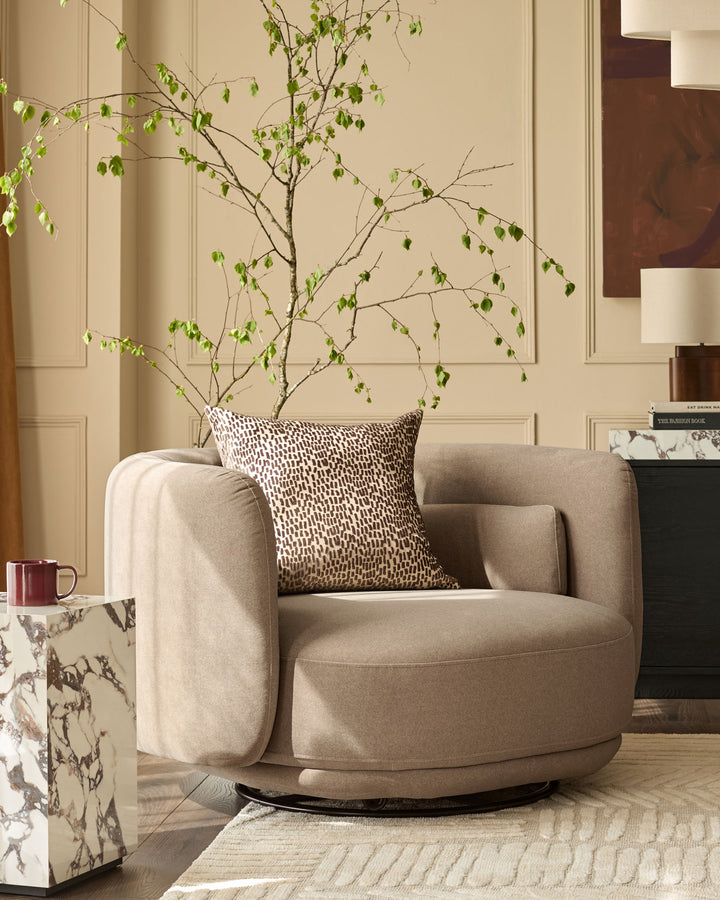 Henry Swivel Love Seat in mocha fabric, featuring a rounded silhouette with curved arms and a rotating base, styled in a modern living room.
