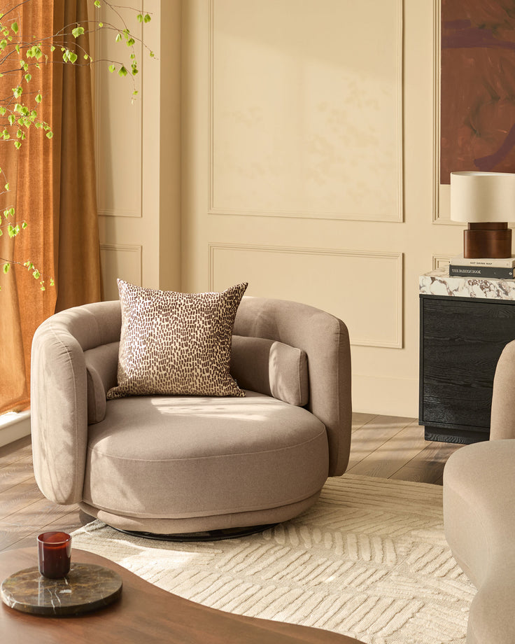 Henry swivel love seat in mocha fabric, shown in a styled living room setting with decorative pillow and rotating base.