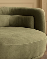Henry swivel love seat in olive green velvet, curved design with rounded armrests, detailed side view.