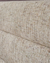Close-up of natural beige textured fabric on Hepworth king-size ottoman bed, showing weave detail and stitching.