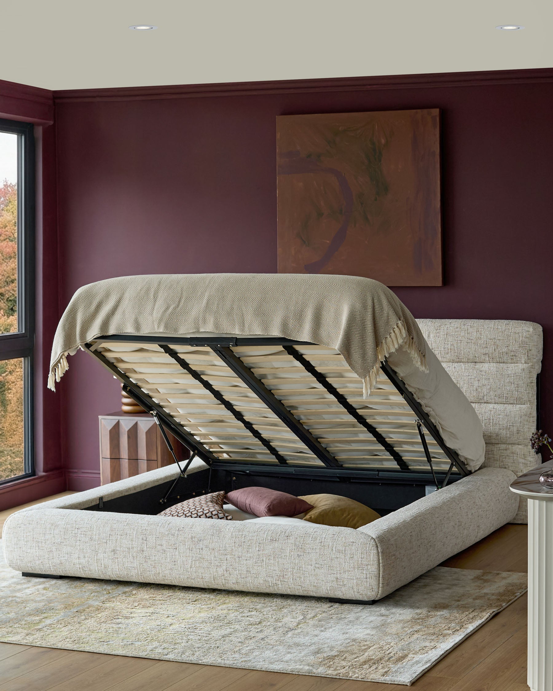 Hepworth king-size ottoman bed in natural fabric with open storage base, showing slatted frame and cushioned headboard.