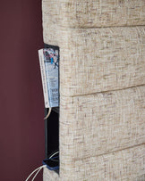 Hepworth King-Size Ottoman Bed in natural beige fabric, shown from side angle displaying textured upholstery and stitched seams.