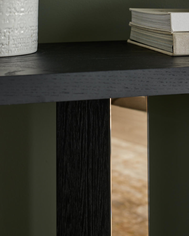 Close-up of a dark wood table with a vase, books and a metallic detail. Modern design.