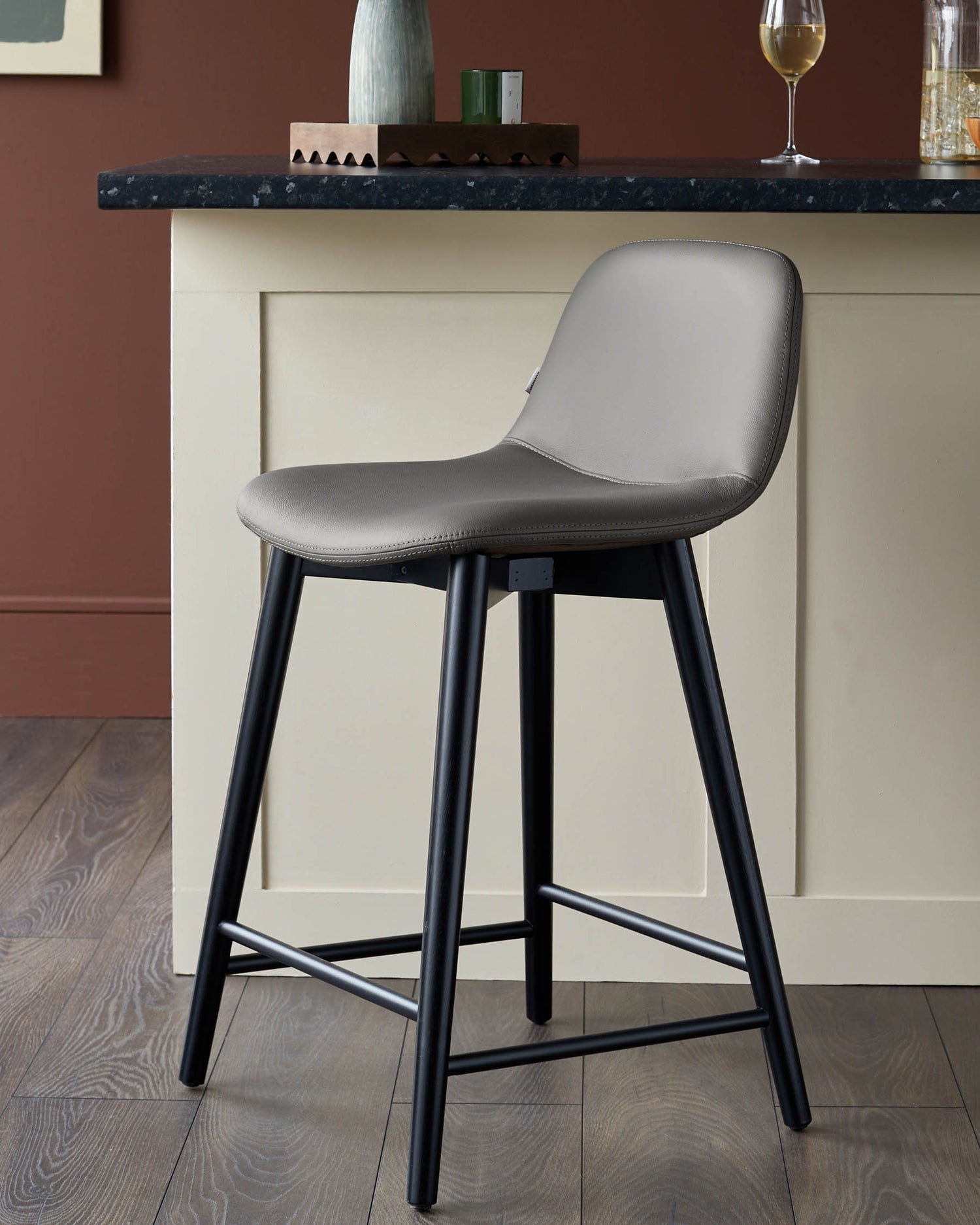 Stylish grey bar stool with black legs in a kitchen setting, perfect for modern homes.