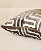 Imani medium cushion in chocolate, featuring geometric chevron pattern in taupe and cream with leather handle detail.
