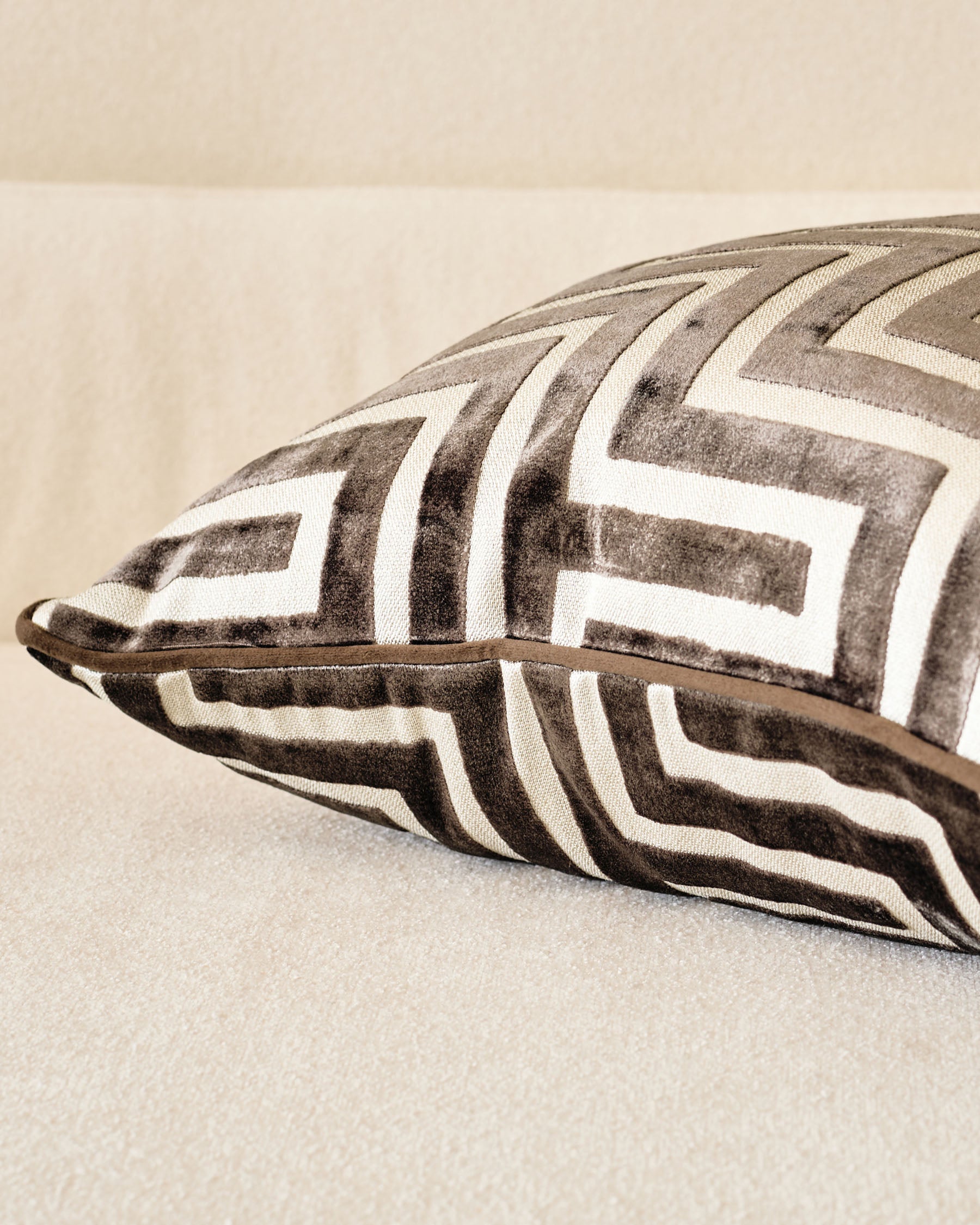 Imani medium cushion in chocolate, featuring geometric chevron pattern in taupe and cream with leather handle detail.