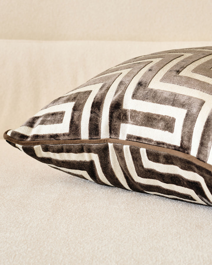 Imani medium cushion in chocolate, featuring geometric chevron pattern in taupe and cream with leather handle detail.