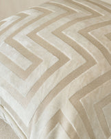 Imani cushion in ivory with geometric chevron pattern in cream and beige tones, close-up detail view.