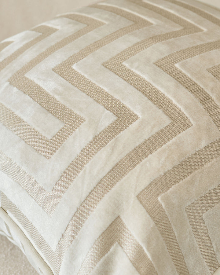Imani cushion in ivory with geometric chevron pattern in cream and beige tones, close-up detail view.