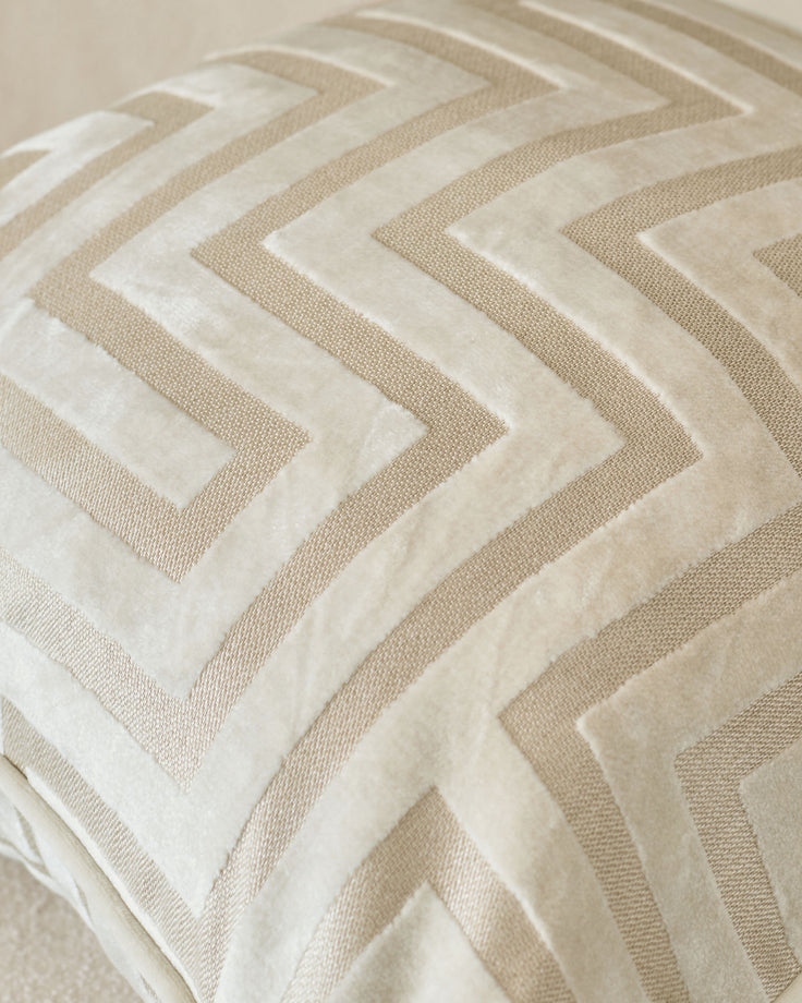 Imani cushion in ivory with geometric chevron pattern in cream and beige tones, close-up detail view.