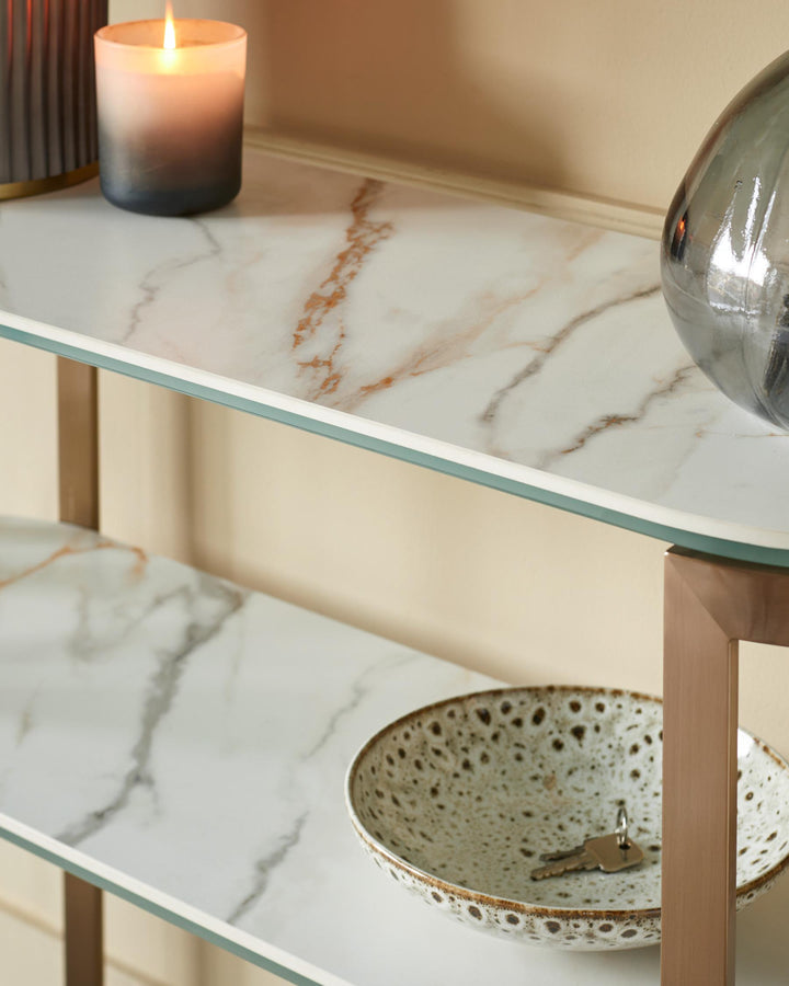 A two-tier shelving unit holds a candle, decorative vase, and a key bowl. The shelves have a marble effect.
