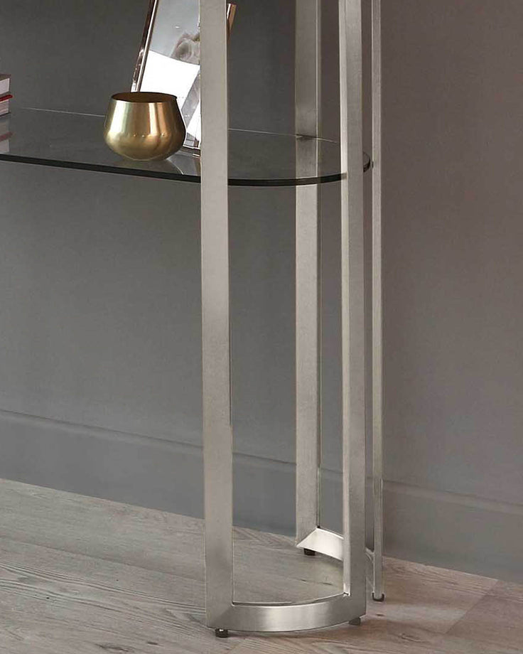 Isla glass and stainless steel console table with white frame, displaying gold bowl on glass shelf.
