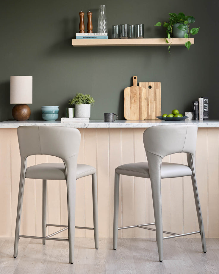 Jackson bar stool in light grey real leather with metal frame, shown at kitchen counter with matching stool.