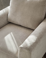 Jacob armchair in light grey fabric, shown in close-up detail highlighting the cushioned seat, backrest, and rolled armrests.
