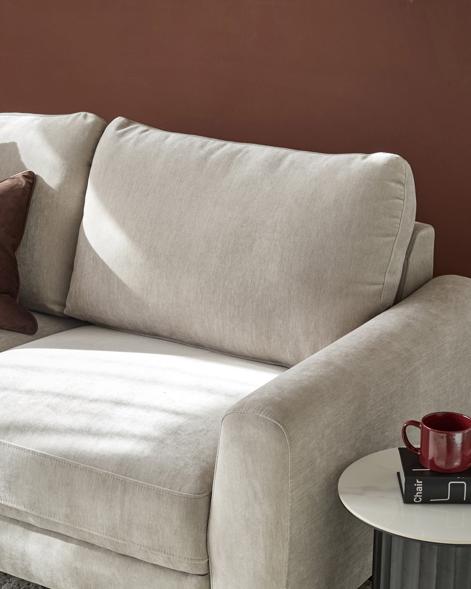 Jacob 3-seater sofa in light grey fabric, angled view showing cushioned backrest and armrest with side table styling.