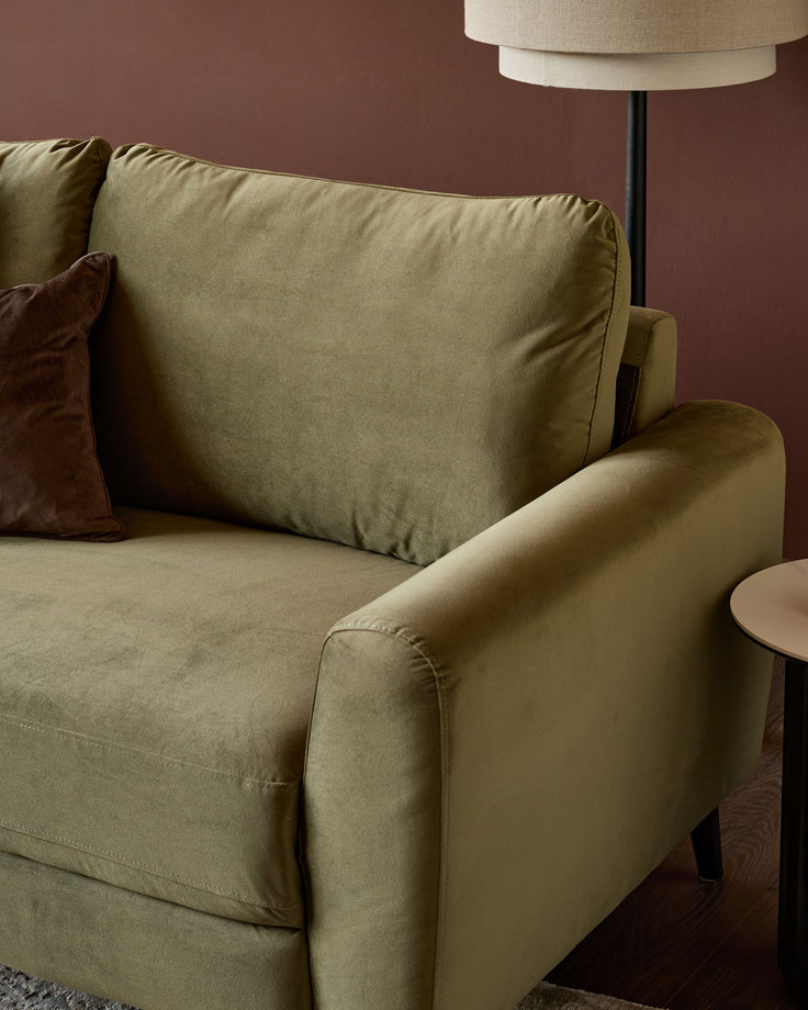 Jacob 3-seater sofa in olive green velvet, side view showing curved armrest and cushioned backrest.