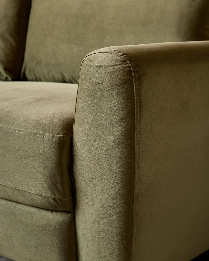 Close-up of olive green velvet armrest on Jacob 3-seater sofa, showing fabric texture and piping detail.