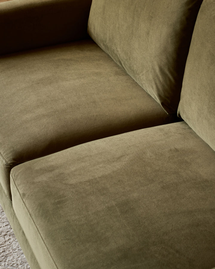 Jacob 3-seater sofa in olive green velvet, close-up detail of seat cushion and armrest construction.