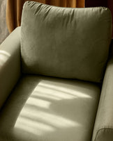 Jacob armchair in olive green velvet, shown from above with cushioned seat and back, sunlit interior view.