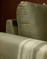 Jacob armchair in olive green velvet, showing side profile with rolled arm and detailed stitching on backrest.