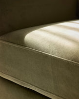 Jacob armchair in olive-green velvet, close-up side view showing plush upholstery and stitched seam detail.
