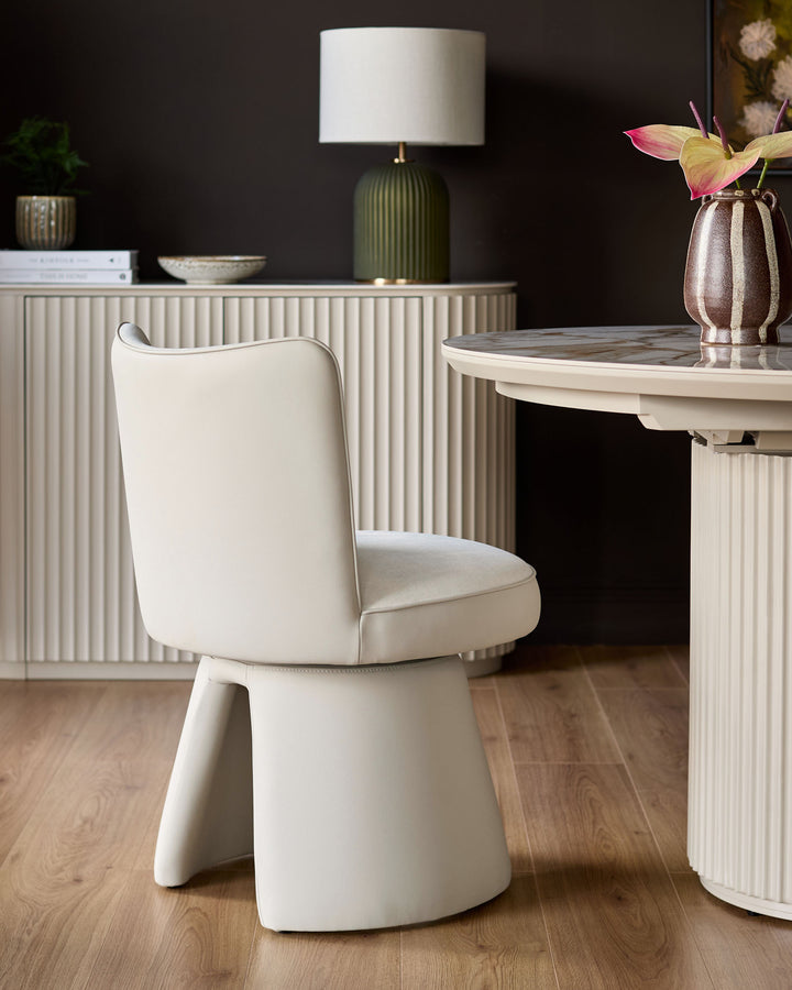 Jenna cream swivel dining chair with curved back and cushioned seat, shown in modern room setting with round table.