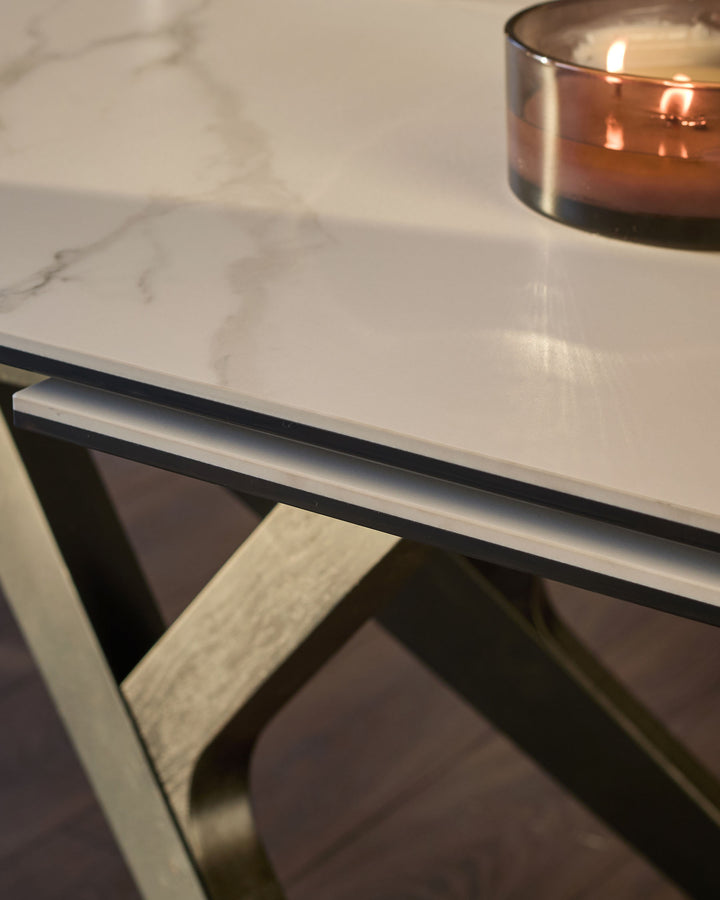 White marble-effect dining table with black metal frame and light wood leg detail, close-up view.