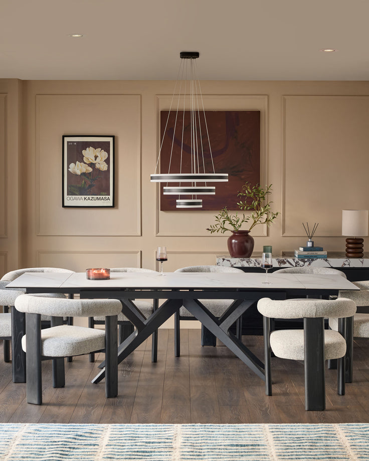 Jennet extending dining table in white ceramic with black X-frame base, shown extended in modern dining room setting.
