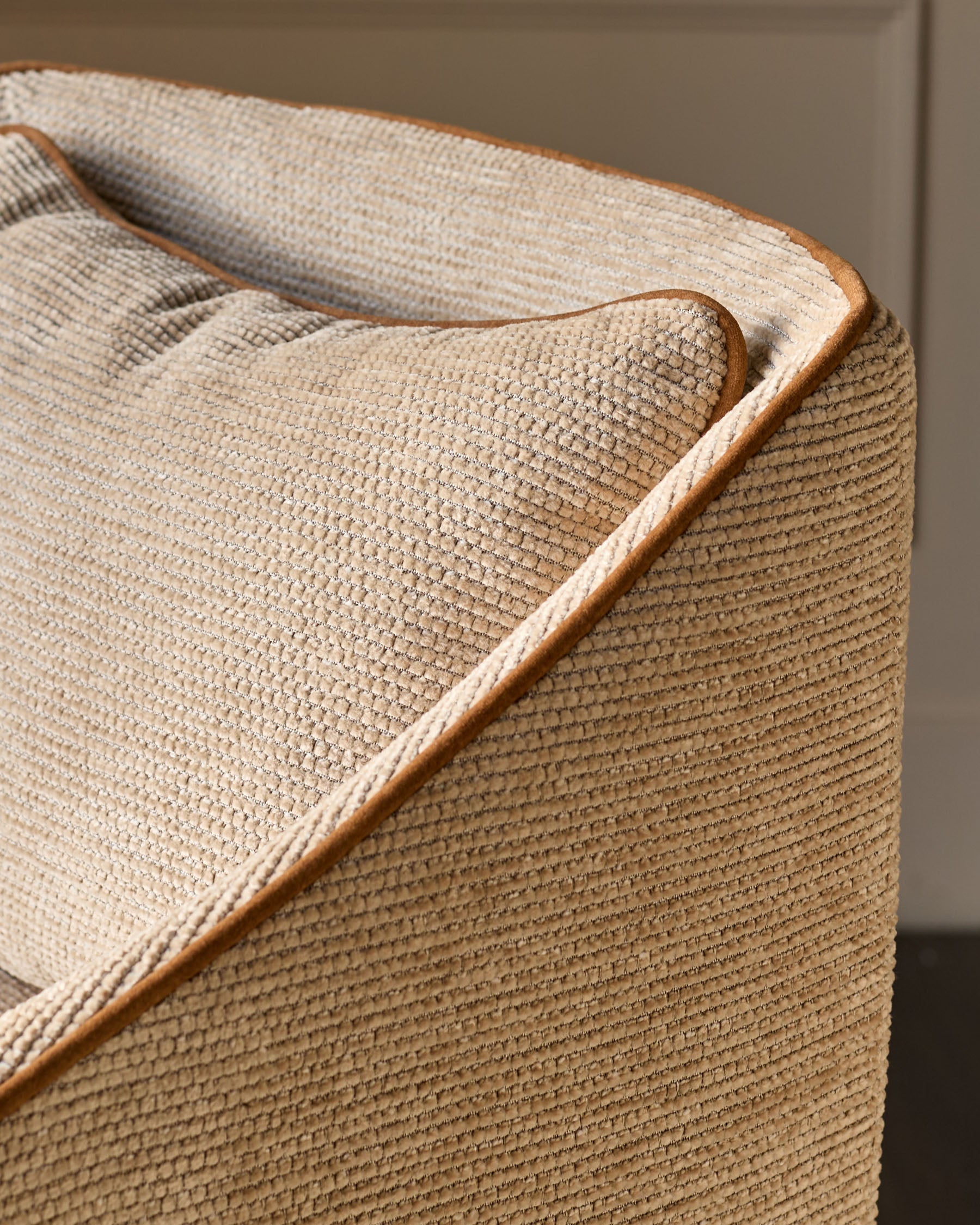 Julep bar stool in honey fabric, close-up of rolled arm detail with tan upholstery and wood trim.