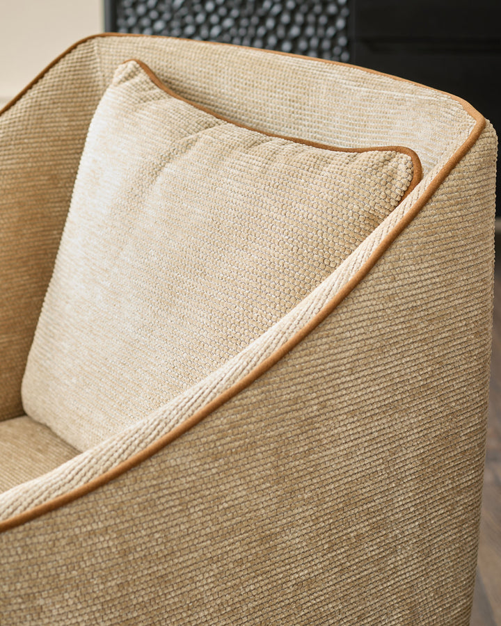 Julep dining chair in honey fabric, close-up detail of curved backrest and piping trim.