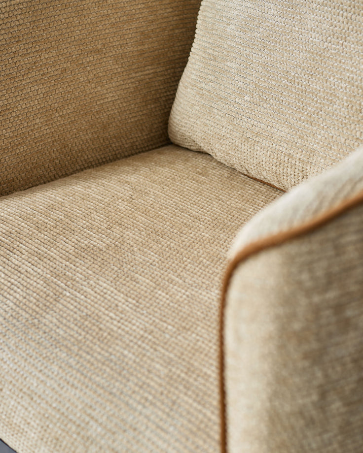 Close-up of honey-colored fabric upholstery on Julep dining chair, showing textured weave and wooden frame detail.
