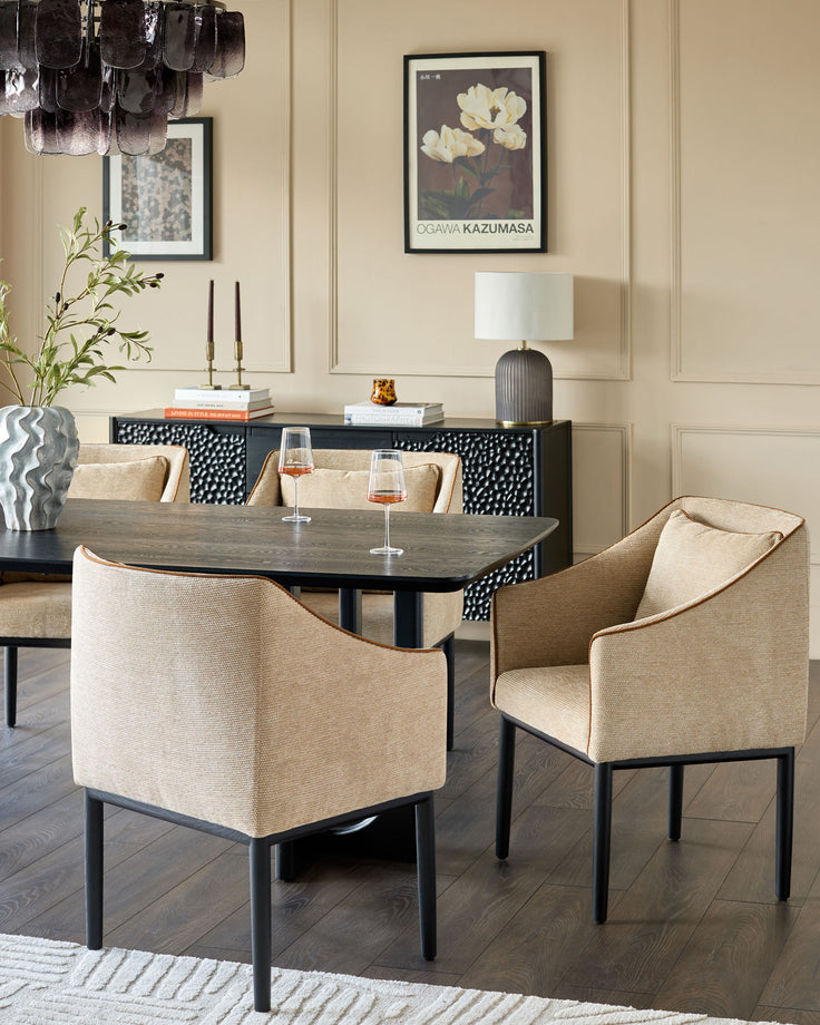 Honey fabric dining chair with black legs, curved back, and arms, shown at dining table in styled room setting.
