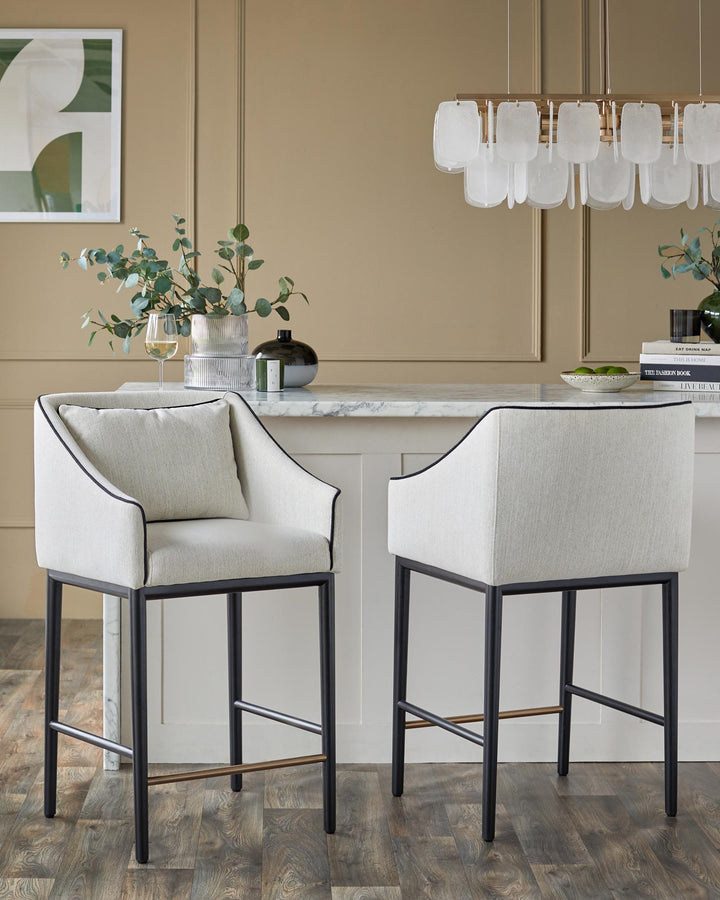 Two stylish bar stools with light upholstery, dark metal frames, and sleek design.