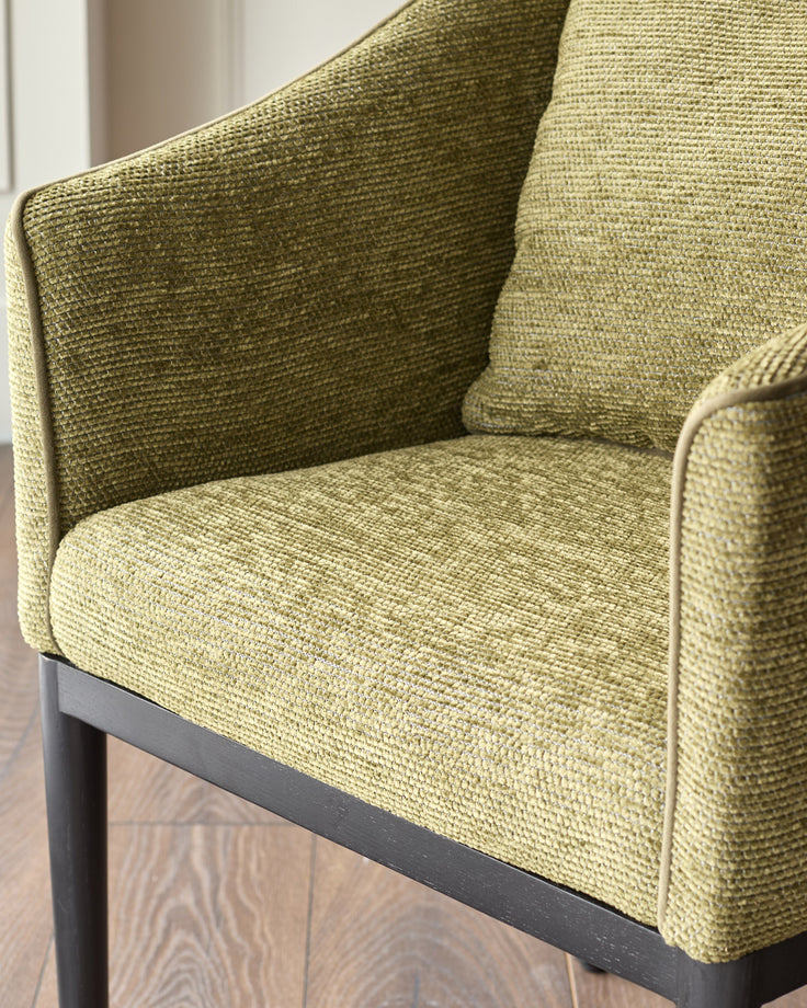 Julep dining chair in olive-green fabric, shown at an angle highlighting the woven texture and dark wooden base.