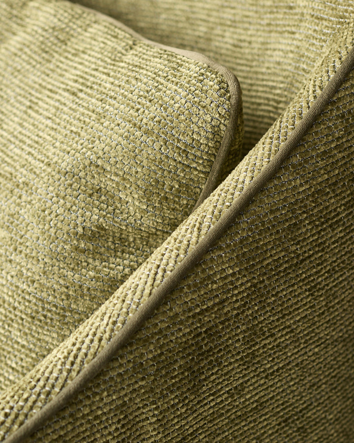 Close-up of olive green textured fabric on Julep dining chair, showing woven detail and piping.
