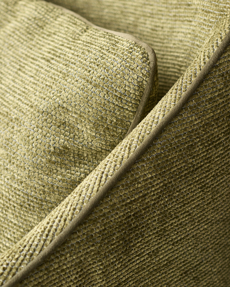 Close-up of olive green textured fabric on Julep dining chair, showing woven detail and piping.
