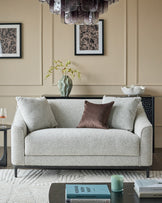 Julep grey 2-seater sofa with rolled arms and black wooden legs in a neutral living room setting.