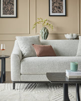 Julep grey fabric 2-seater sofa with black wooden legs, styled in a neutral living room setting.