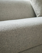 Close-up of grey fabric texture on Julep Blackwood 3-seater sofa, showing woven upholstery detail and cushioned armrest.