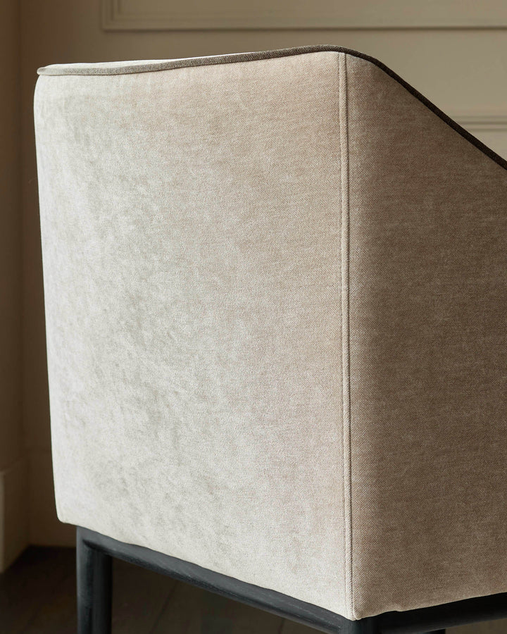 Julep dining chair in champagne fabric, shown from side angle displaying upholstered back and seat construction.