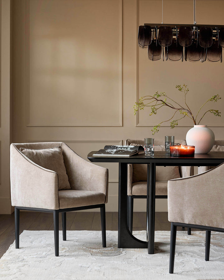 Julep dining chair in champagne fabric with black wooden legs, shown in a styled dining room setting.