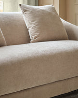 Champagne fabric 2-seater sofa with cushioned back and seat, featuring a coordinating throw pillow.