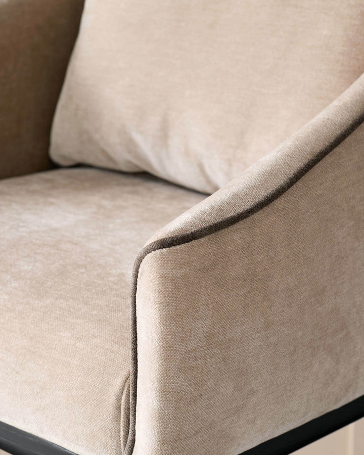 Champagne fabric bar stool, close-up of curved armrest and seat upholstery detail.